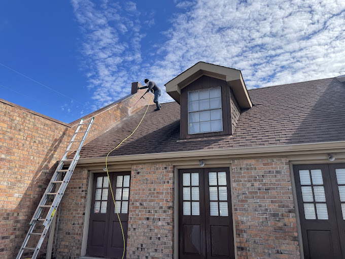 A man on a ladder working on a roof