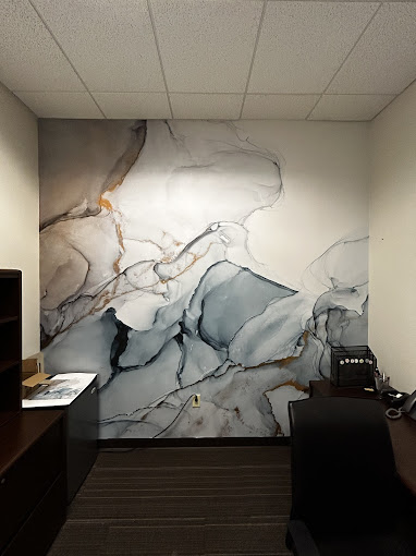 A marble wall in an office with a desk and chair